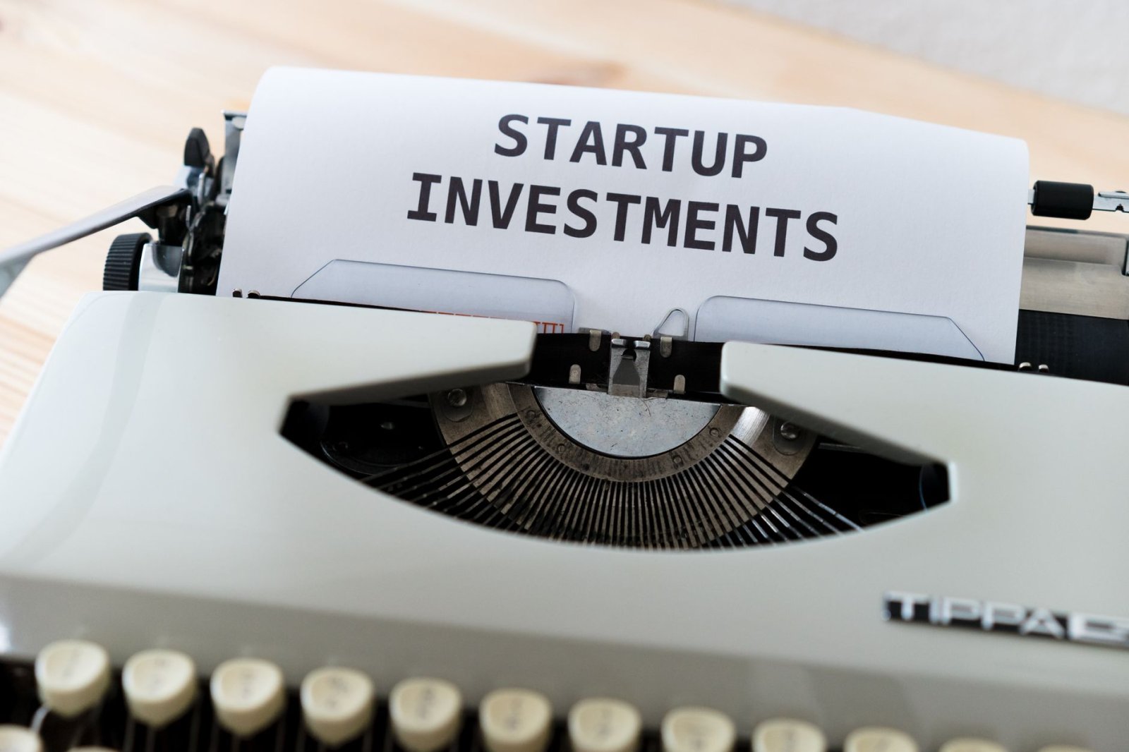 A vintage typewriter displaying a page with the words 'Startup Investments,' ideal for business and entrepreneurship the