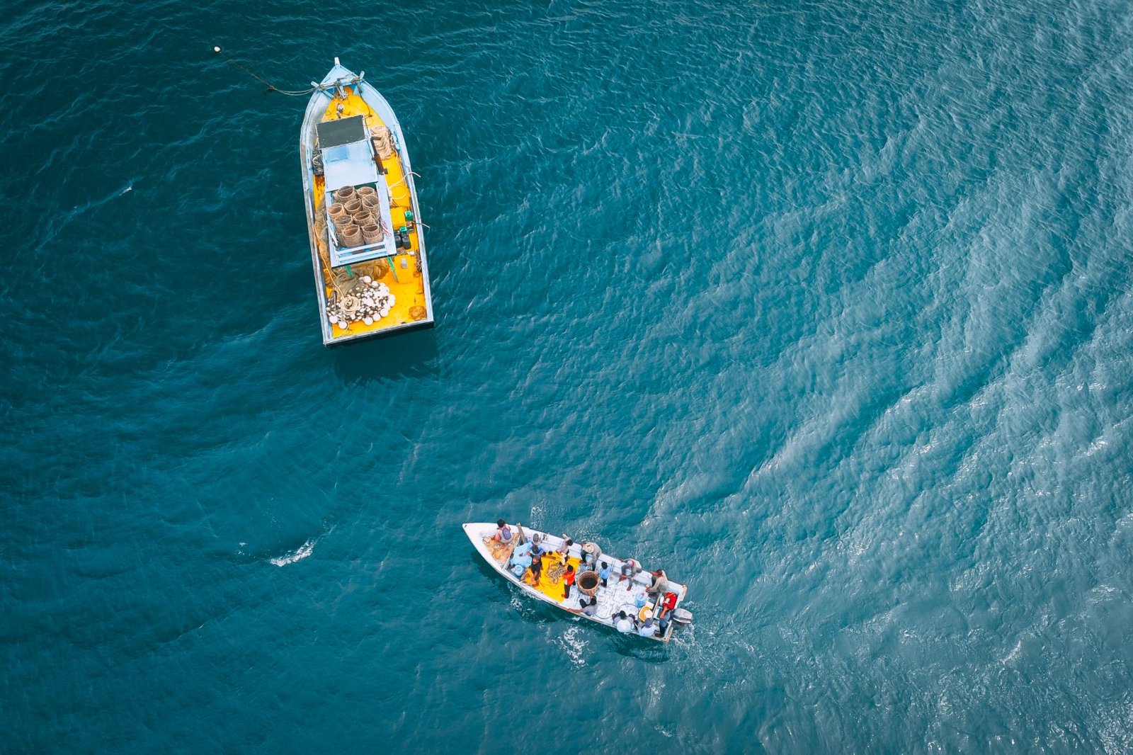 Top view of vessels with different equipment sailing in turquoise water of endless ocean