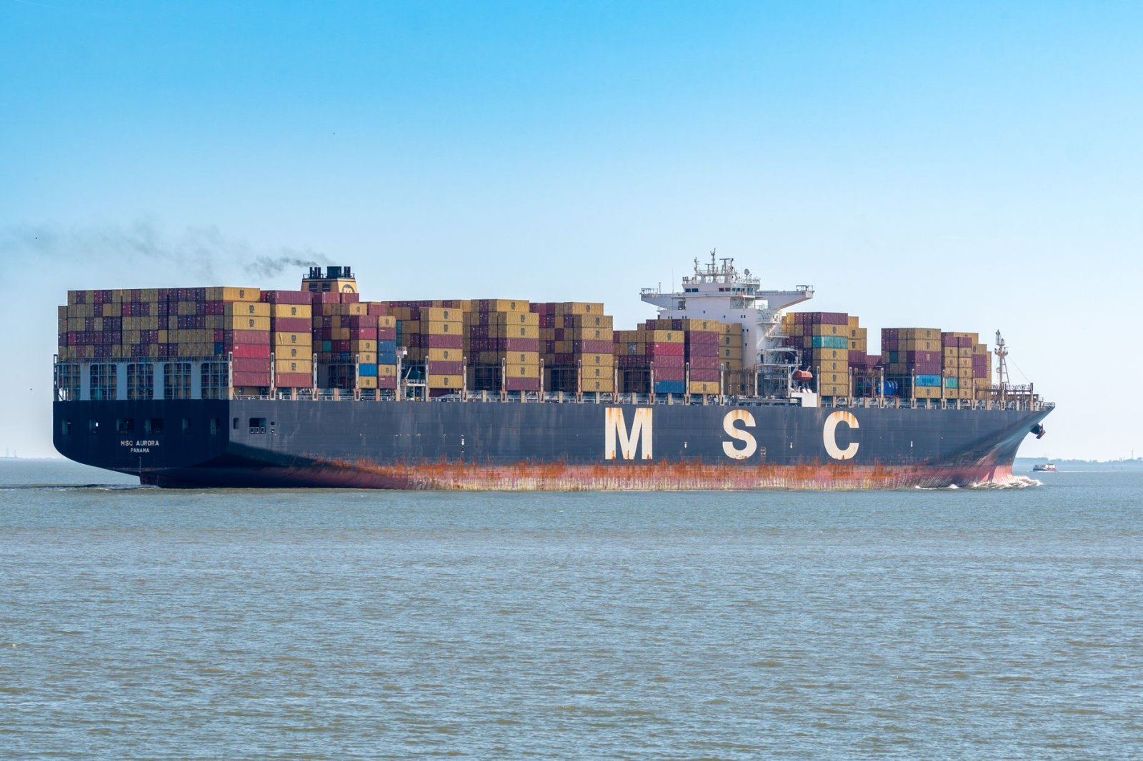 MSC container ship transporting cargo on open sea under clear sky.